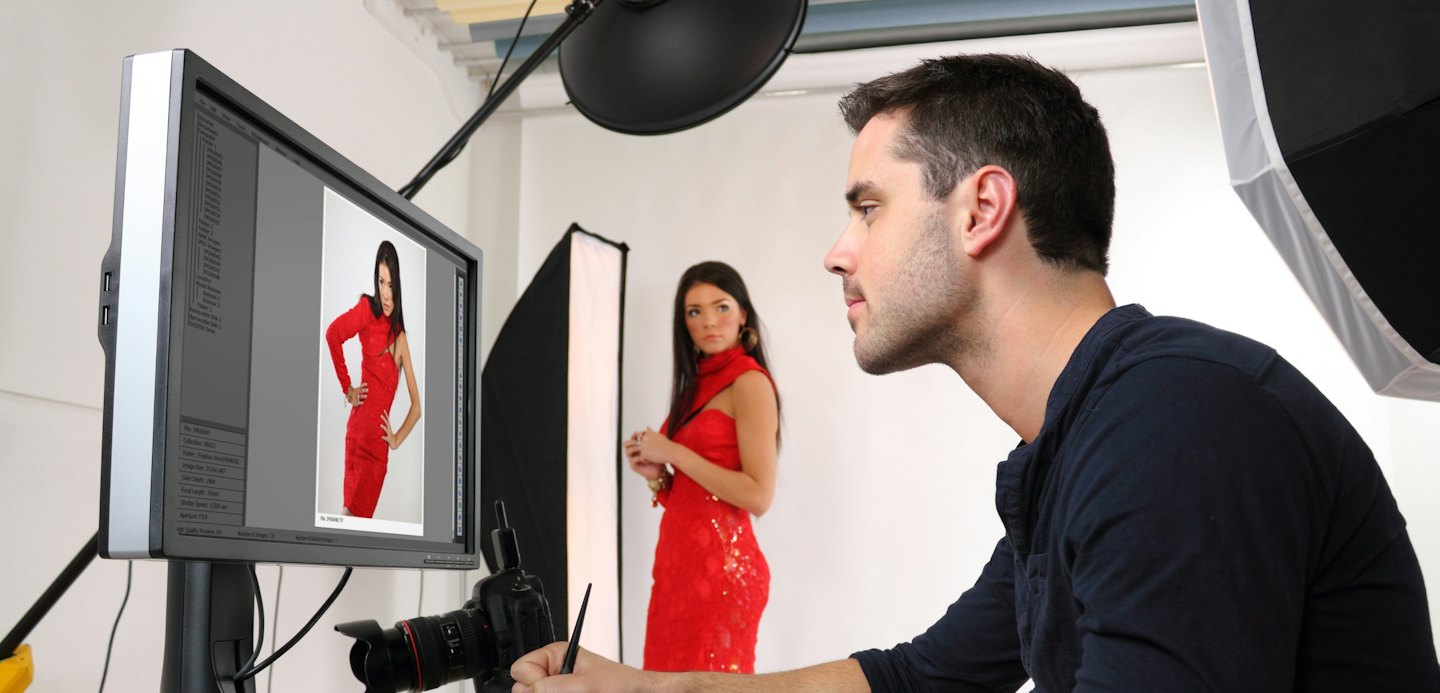 Fotograf überprüft Model-Fotos auf einem großen Monitor.